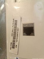 Label showing Polycom part number 2215-24414-001 on wall plate with RJ45 Cat6 jack