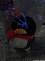 Front view of sealed package showing plush QQ Penguin keychain