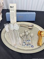 Overview of all flatware on metal tray with box