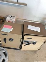 Front view of both beige safes showing doors, dials and handles