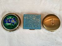 Three closed compacts showing exterior designs