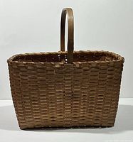 Front view of woven wood splint basket with handle