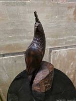 Front left view of carved ironwood quail on rock base