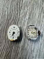 Front view of both Hamilton and Bulova watch movements showing dials