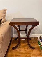 end table beside sofa showing curved legs and stretcher