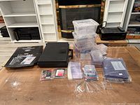 Whole lot overview on table showing hard case, binder pages package, storage bins, card holders, sleeves, display stands