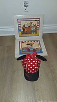 All items together: two framed prints and Minnie Mouse cap