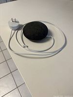 Top view of Google Home Mini with power adapter and cable