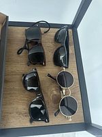 All four sunglasses displayed on wooden shelf