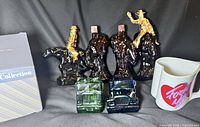 Group shot showing three cowboy bottles, two car bottles, mug, and mug box