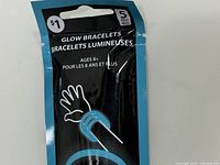 Front of sealed pouch showing product name, quantity (5 pieces), age 8+ and blue bracelet graphic