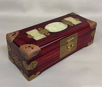 Closed jewelry box angled view showing jade plaques and brass hardware