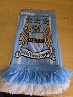 Packaged Manchester City scarf showing crest and fringe