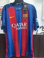 Front view of Nike FC Barcelona jersey showing stripes, crest, sponsor logo, size Large