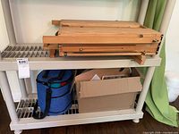 wooden folding easel and blue storage bag on shelving