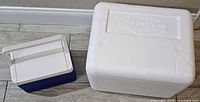 Igloo blue plastic cooler and Omaha Steaks white foam cooler closed side by side