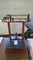 Full view of antique beam table scale on wooden surface