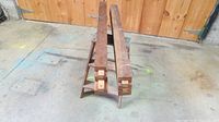 two wooden slide rails on step ladder, ends showing dovetail extensions