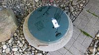 Top view of concrete ring with green plastic lid