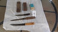 All three knives and three stones on cloth