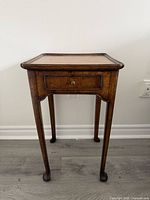 Full frontal view of wood side table showing overall form and drawer