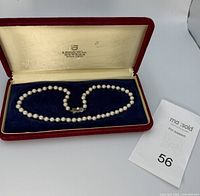 Necklace displayed inside red velvet K. Mikimoto box with lot slip visible