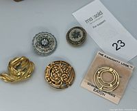 All five scarf clips laid out including Eaton card
