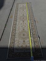 Full view of runner rug with tape measure showing length