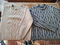 Both sweaters laid flat showing full view