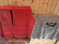 Red and brown fabrics draped to show color, weave and center slits
