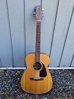 Full front view of Fender F-200 dreadnought guitar leaning against wall
