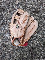 Full view of folded tan leather Mizuno glove showing overall wear