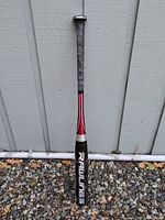 Full view of Rawlings baseball bat leaning against wall