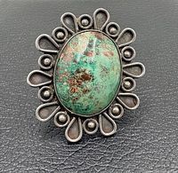 Front view of ring showing turquoise cabochon, scalloped and beaded silver border