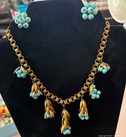 Full view of necklace on stand with earrings