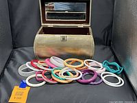 Jewelry box open showing mirror and interior lining with bangles displayed in front