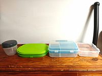 All four containers lined up showing size and lid colors