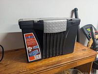 Front angled view of Storex file box showing brand label, ribbed front, latch