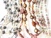 Close view of bead types, colors and finishes across all three necklaces