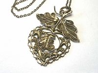 Full view of gold tone filigree pendant necklace with chain