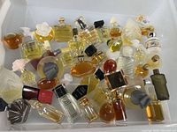 Top view showing entire assortment of over thirty miniature perfume bottles in clear bin