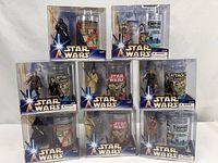 All eight sealed Star Wars figure & glass sets arranged in three rows