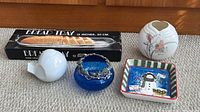 Group shot of all five items: boxed glass tray, blue bowl with pewter overlay, white Yamaji vase, snowman dish, white bird figurine