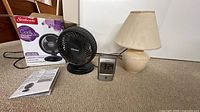 All three items together: fan with box and manual, lamp with shade, digital clock