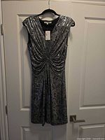Front view of black and silver metallic sleeveless dress on hanger