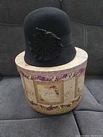 Hat on top of decorative box showing overall design and embellishment