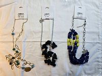 Overview of three new tagged necklaces on white background