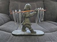 Right side view of soapstone Inuit fisherman figurine with fish on pole