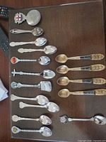 All fifteen spoons laid out on surface