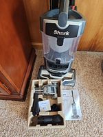 Full view of Shark Lift-Away vacuum with accessory tray and manual